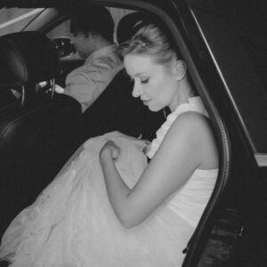 Bride in white dress stepping out of the vehicle