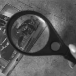 Damage assessment over an old photo using a magnifier and revealing a honeycomb pattern