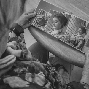 Elderly woman holding a vintage album before being digitalised