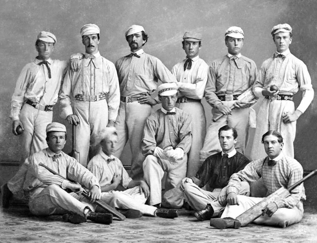 The same cricket team portrait after restoration, with the damage repaired